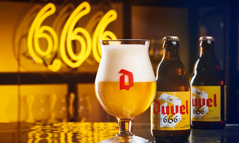 Duvel 666 op tafel met een neon lamp erachter Duvel 666 bier in glas en flesjes op tafel met een 666 neon lamp erachter